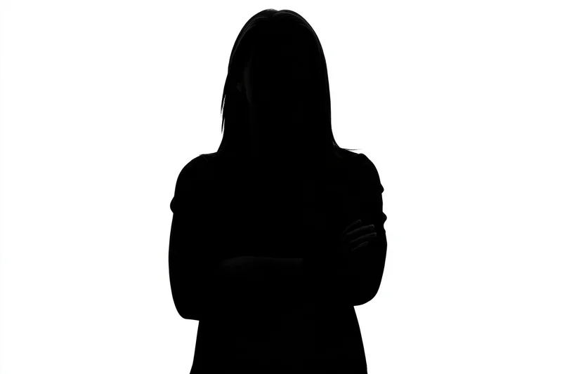 Silhouette of a woman standing with arms crossed against white background