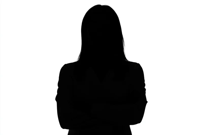 Silhouette of a woman with arms crossed against white background