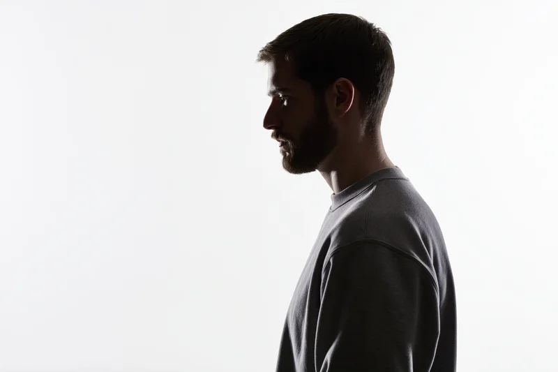 Bearded man in profile silhouette against white background with copyspace
