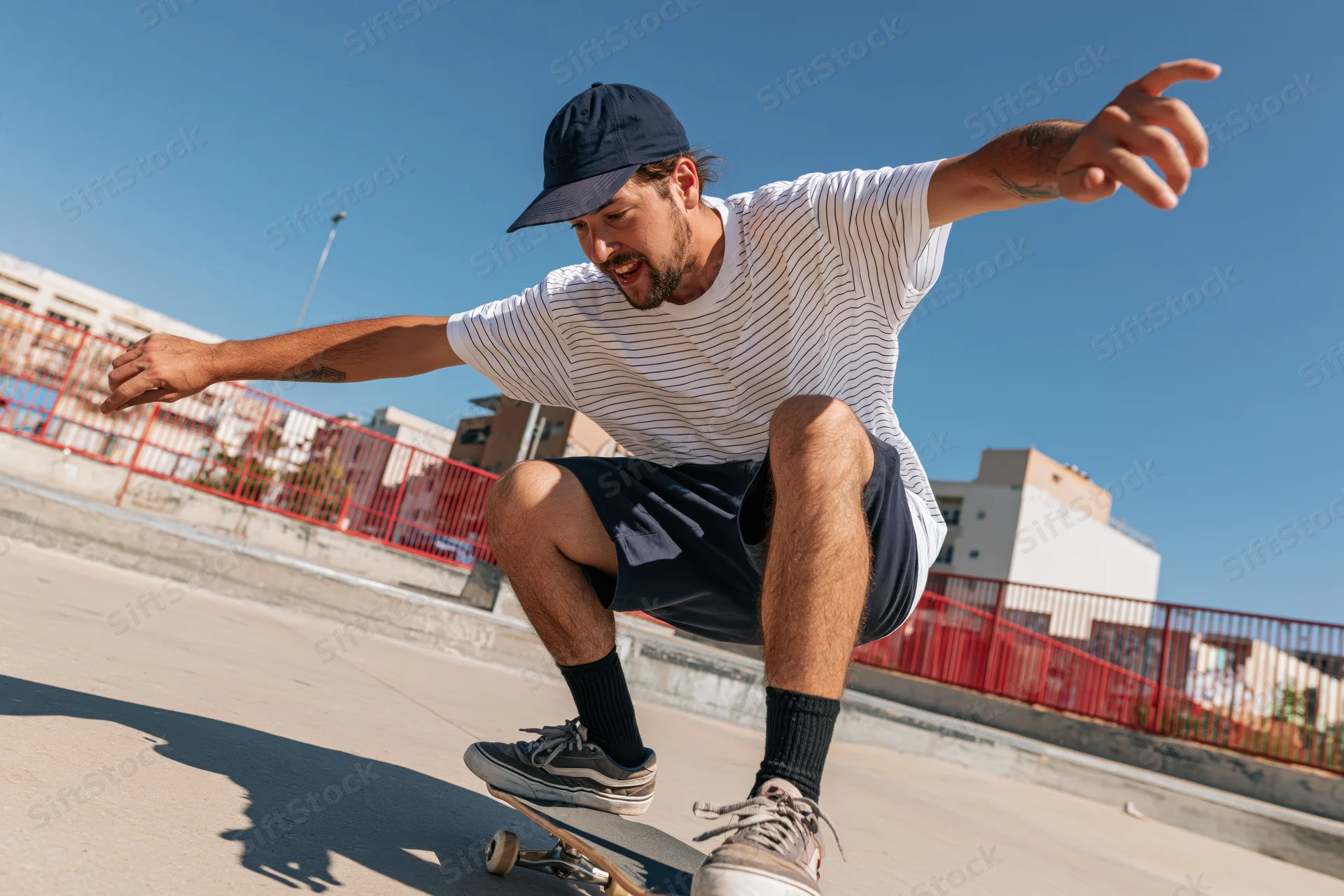 Young man performing a skateboarding trick on a concrete surface at an outdoor skatepark