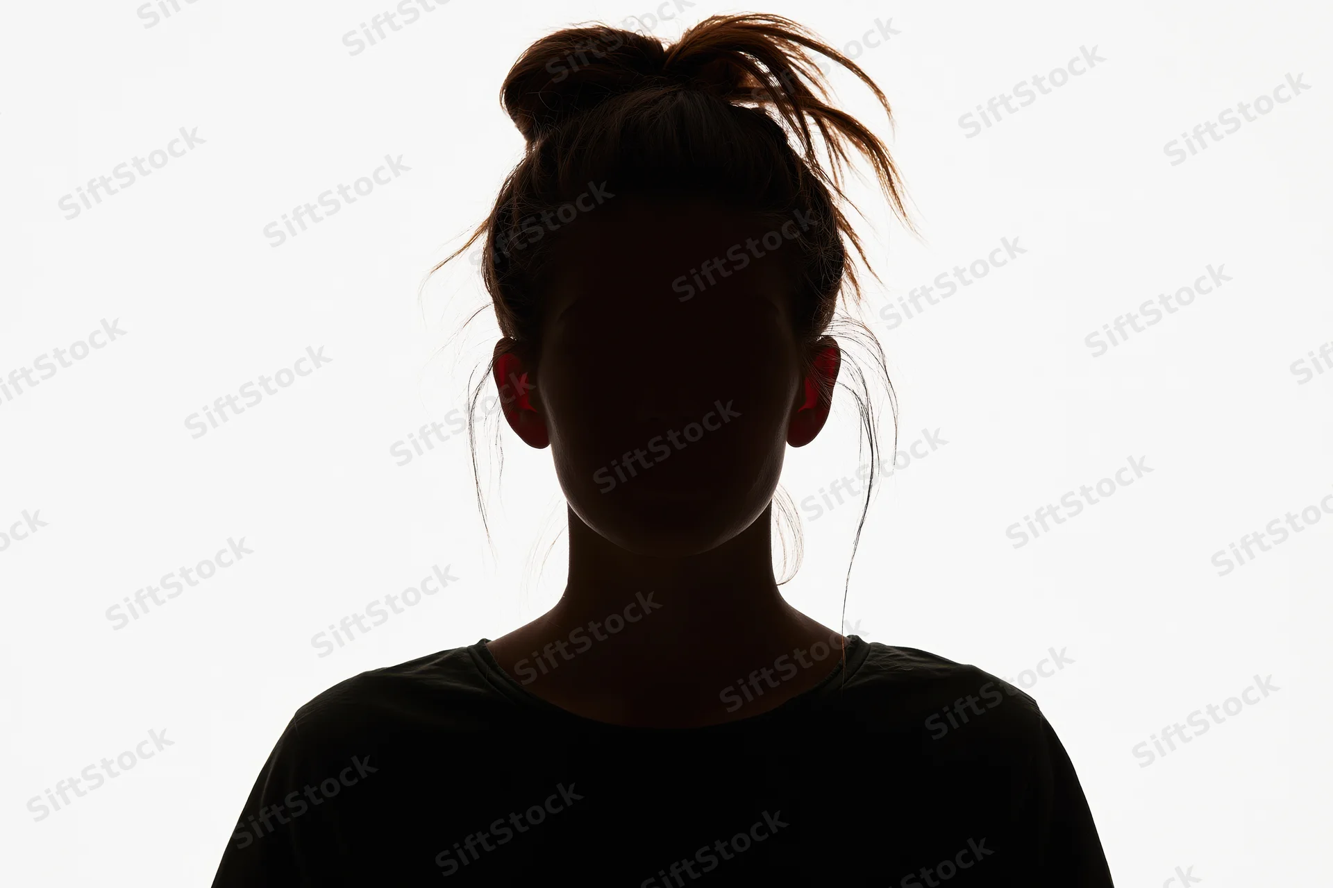Silhouette of a young woman facing forward with hair in a bun against white background