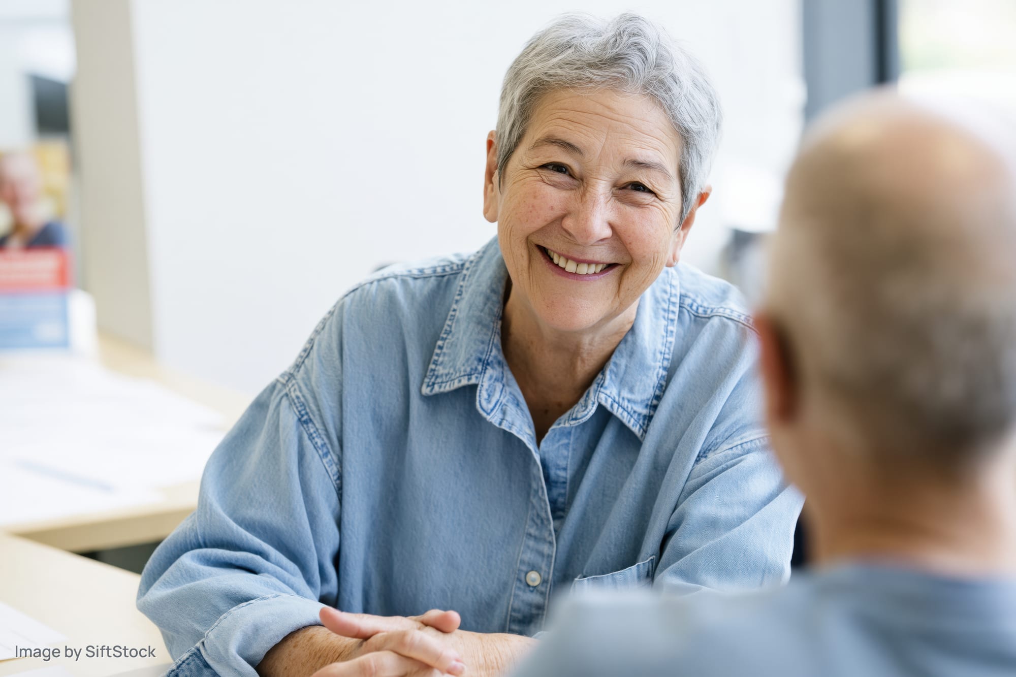 Senior woman smiling during a consultation in an office setting