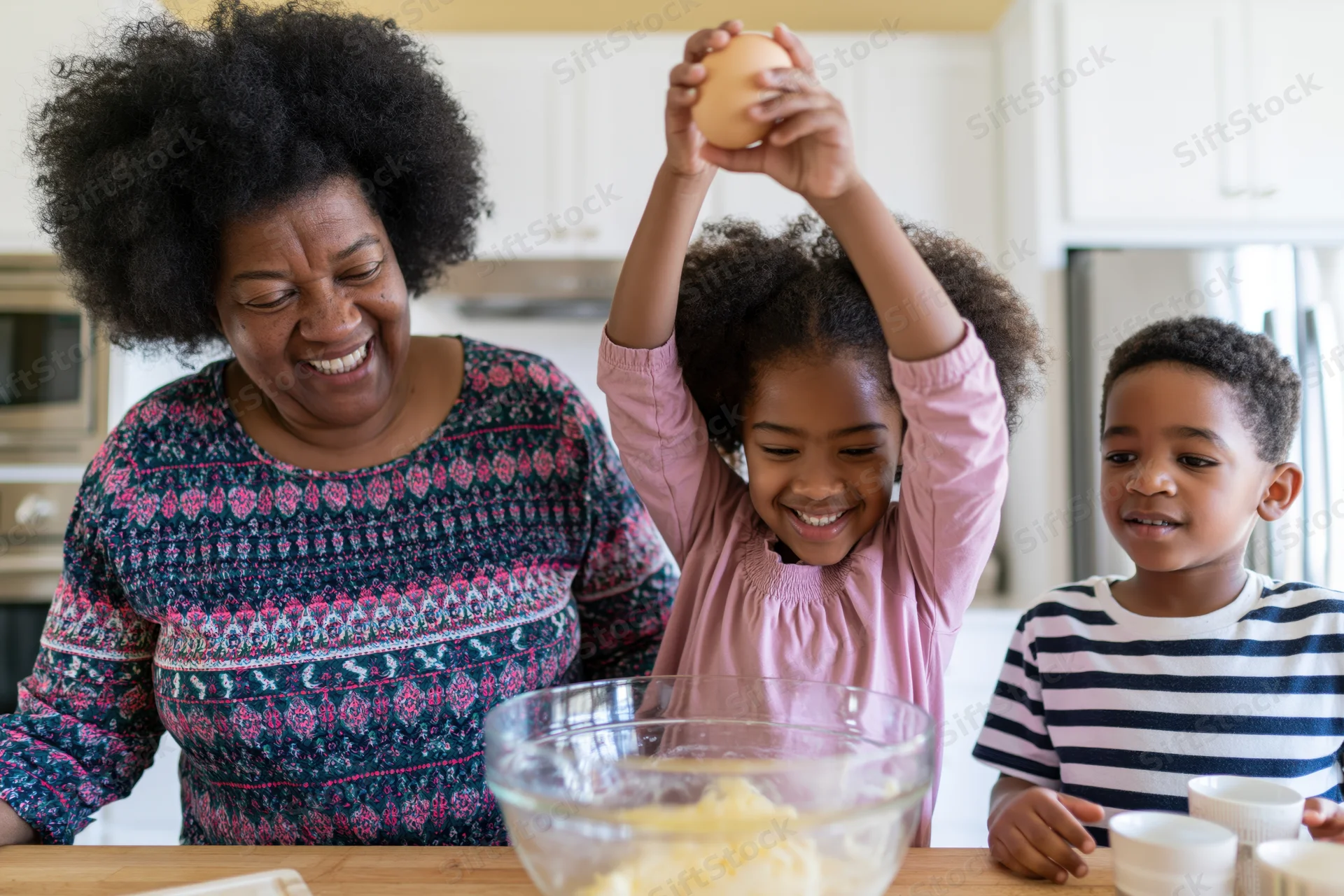 Woman and children baking together in kitchen, girl holding egg above bowl, smiling faces around counter