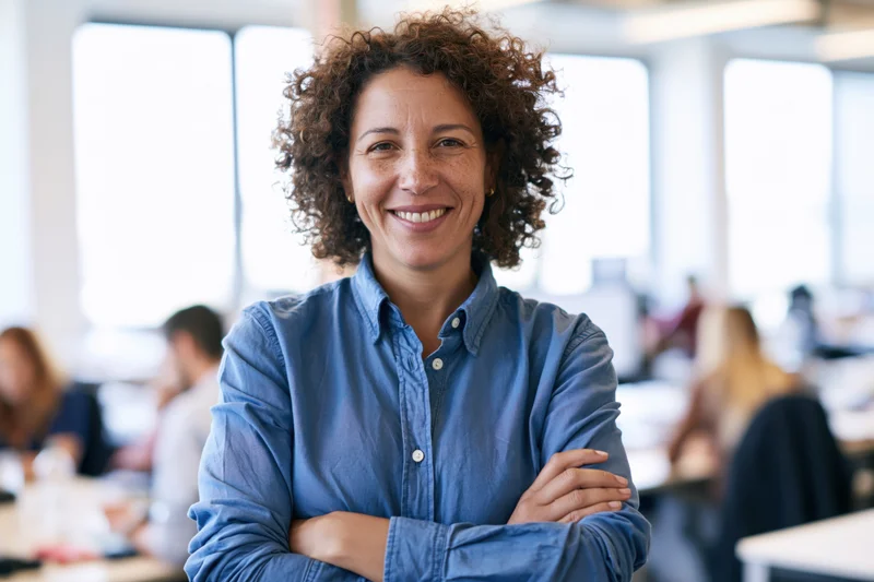 Woman smiling with arms crossed in office environment