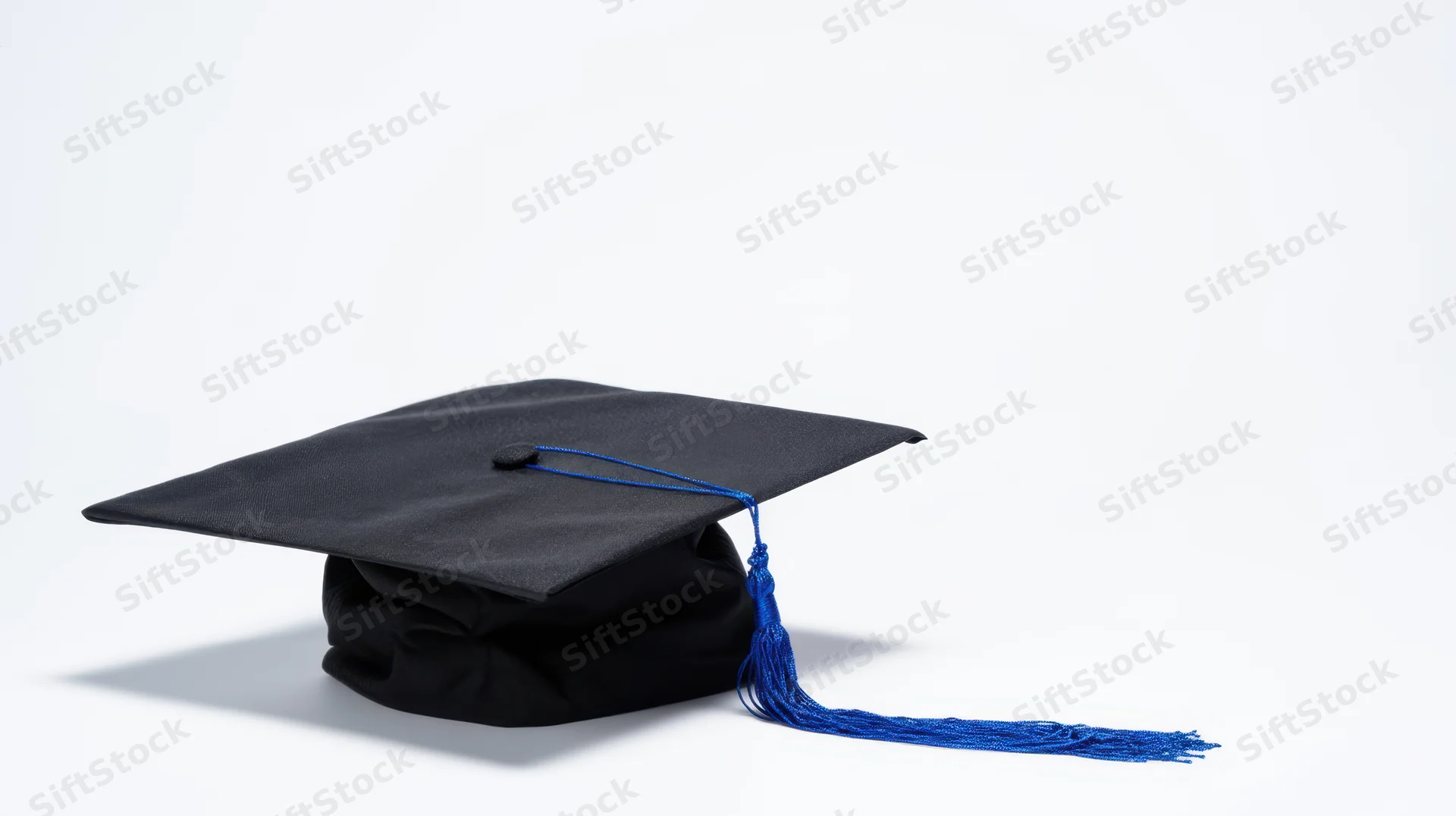 Black graduation cap with blue tassel on white background