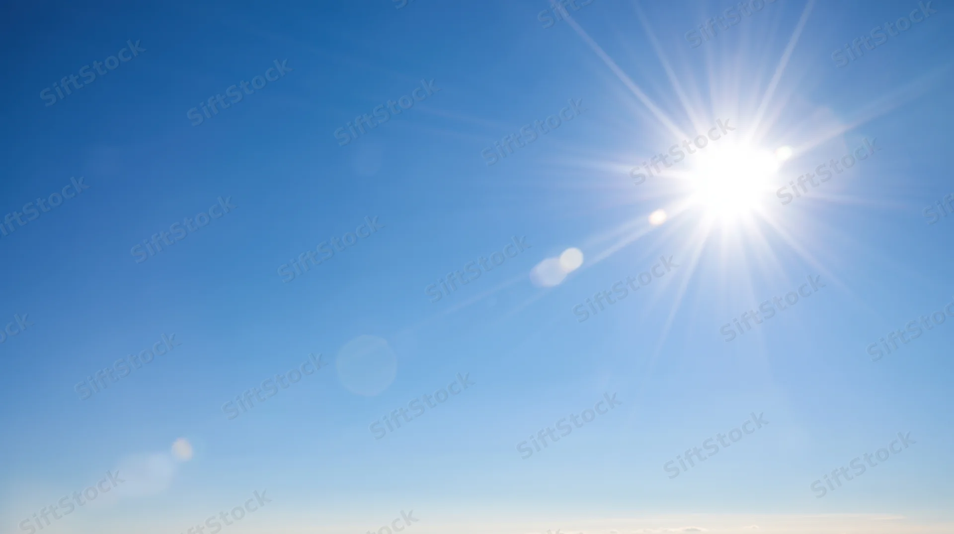 Bright sun radiating light across a clear blue sky during daytime