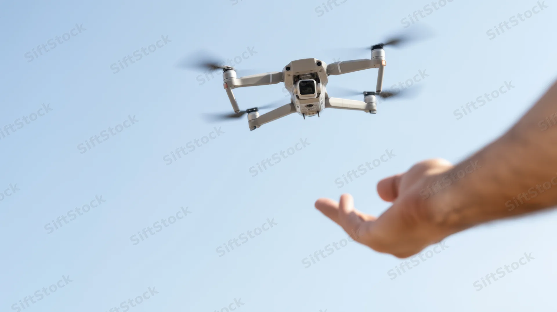 Hand releasing a drone into the sky during daytime outdoor operation