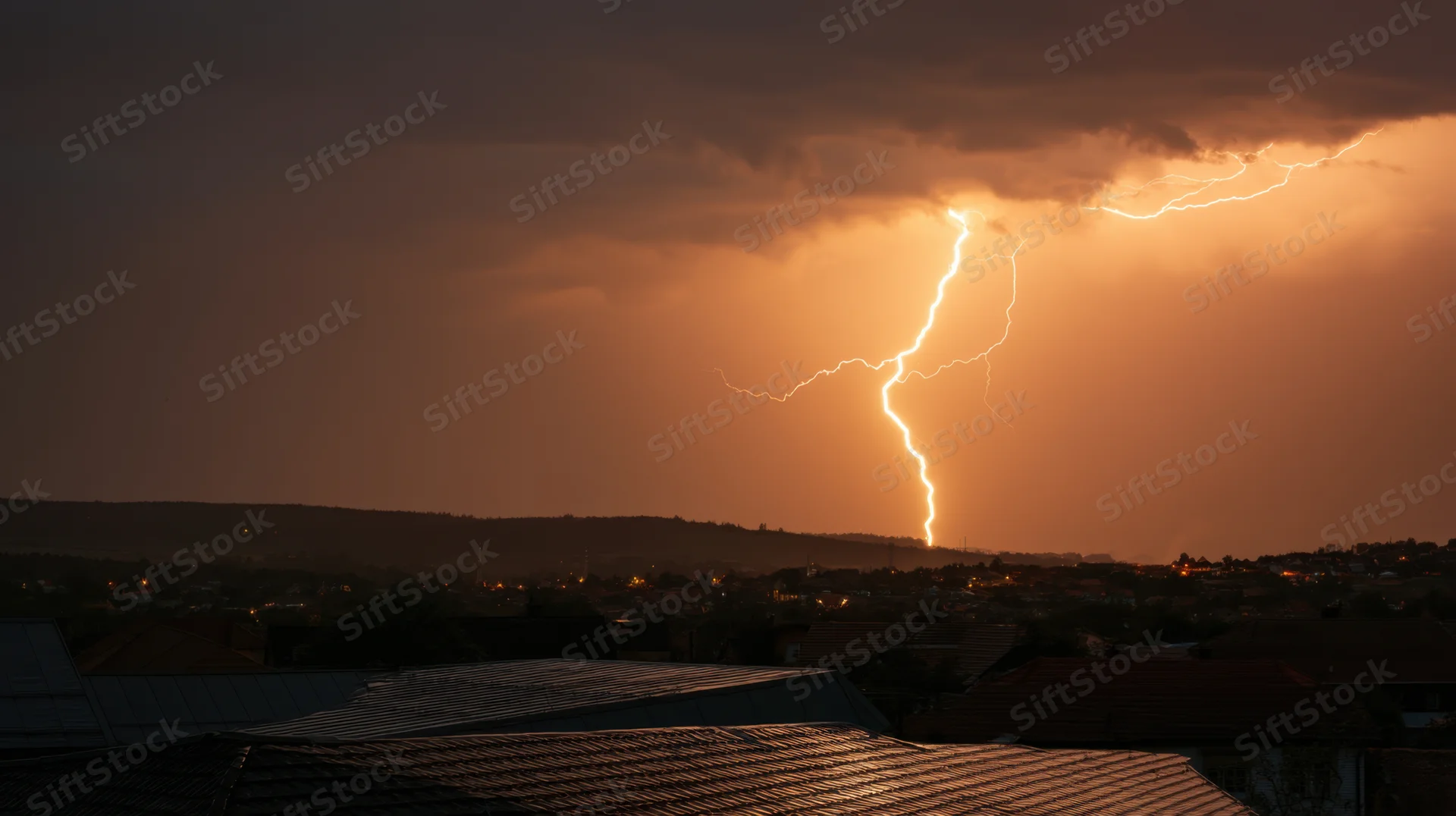 Jagged lightning bolt striking over a residential cityscape at dusk