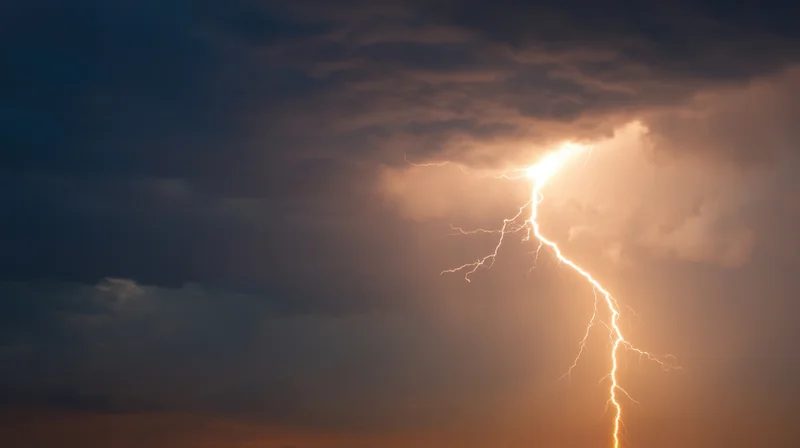 Lightning striking through dark storm clouds at night