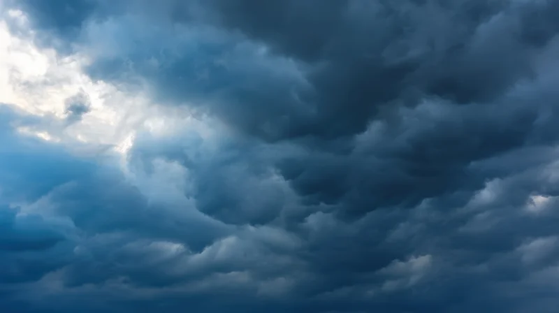 Dramatic stormy sky with dark clouds and sunlight breaking through