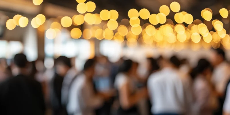 Blurred crowd at indoor reception with warm bokeh lights overhead