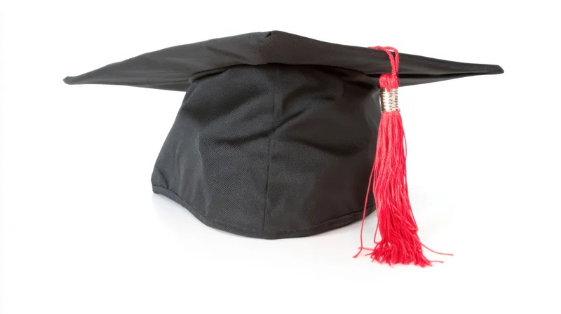 Black graduation cap with red tassel on white background