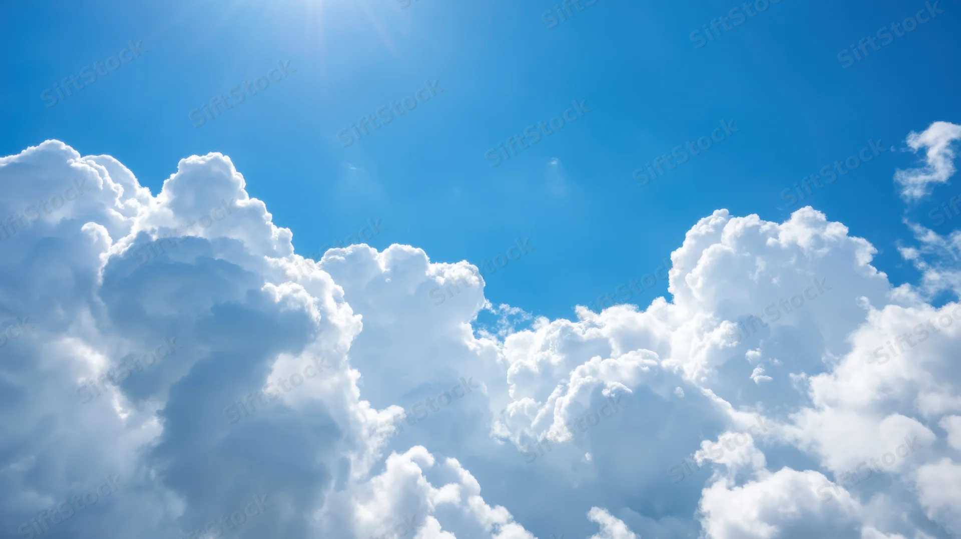 Bright blue sky filled with fluffy white clouds under sunlight