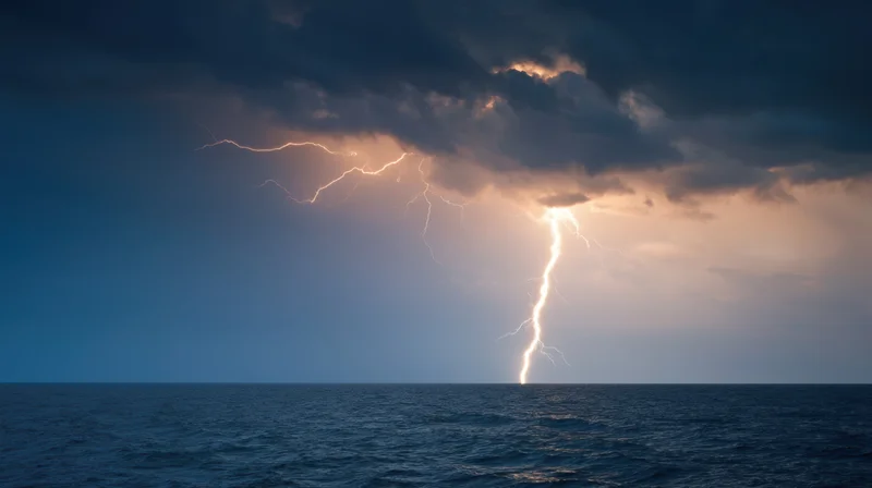 Lightning striking the ocean under dark storm clouds at twilight