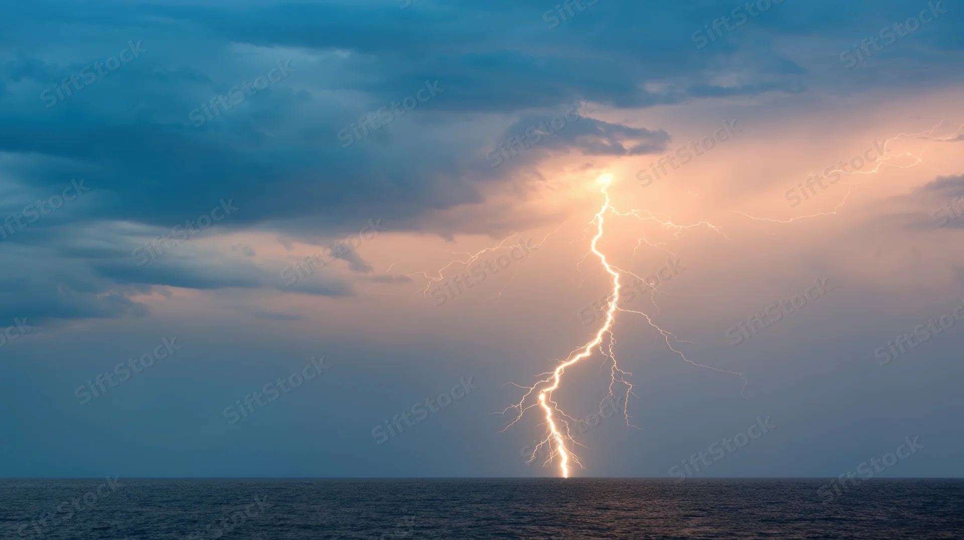 Lightning striking the ocean under stormy clouds at dusk