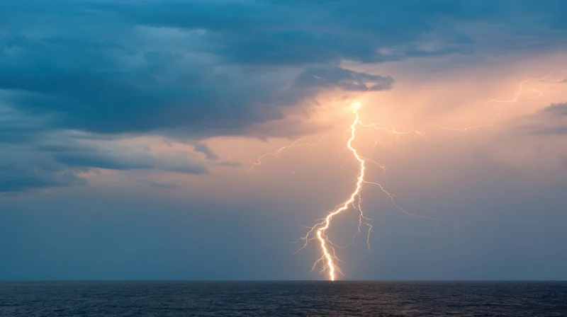 Lightning striking the ocean under stormy clouds at dusk