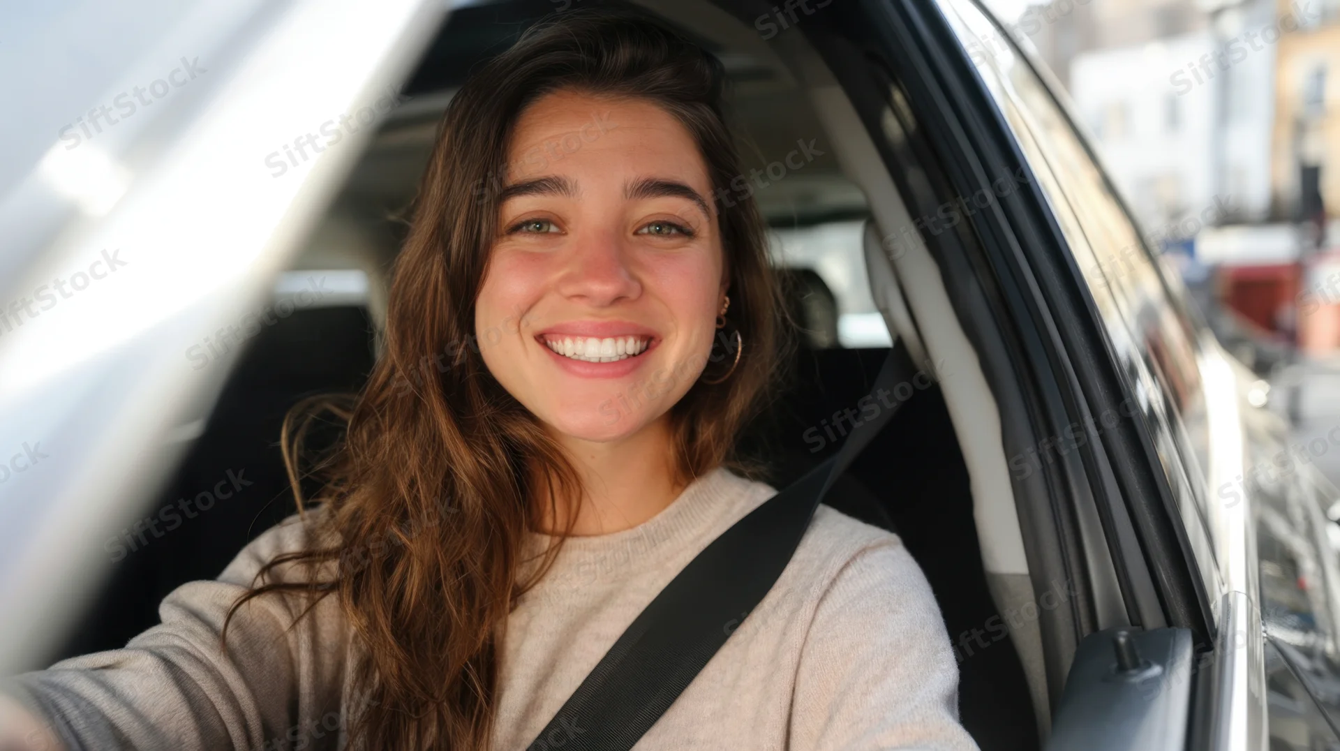 Smiling woman driving a car in an urban setting