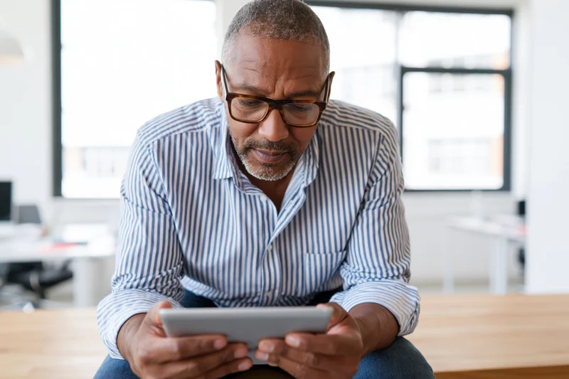Man using tablet while sitting at desk in office