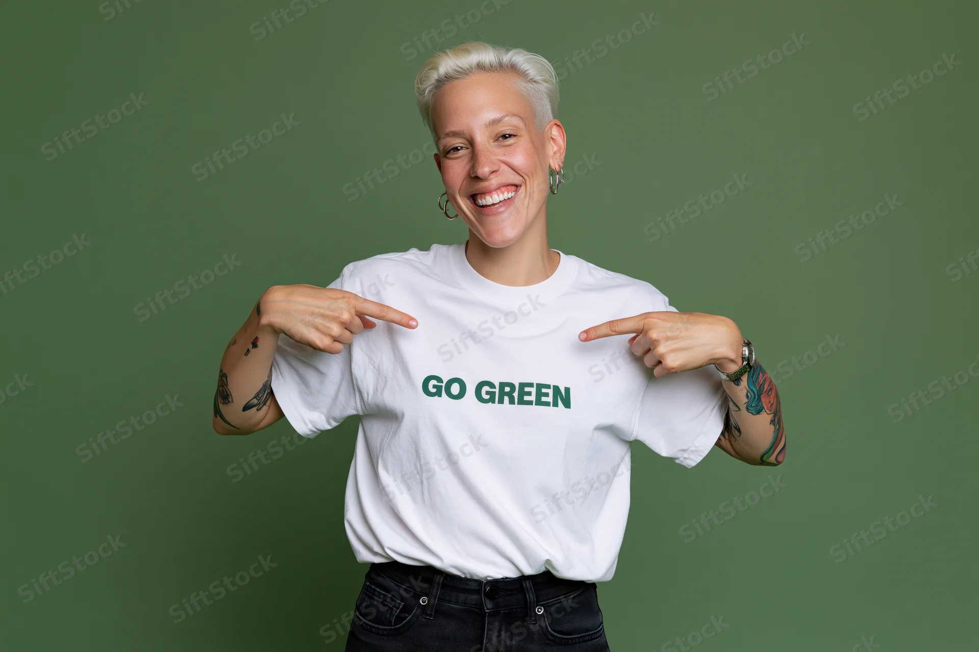 Woman smiling and pointing at go green text on white tshirt against green background