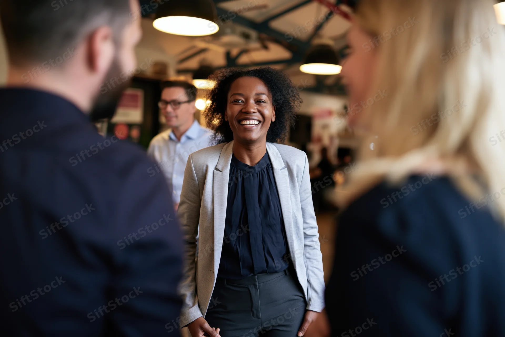 Woman smiling during office social interaction with colleagues