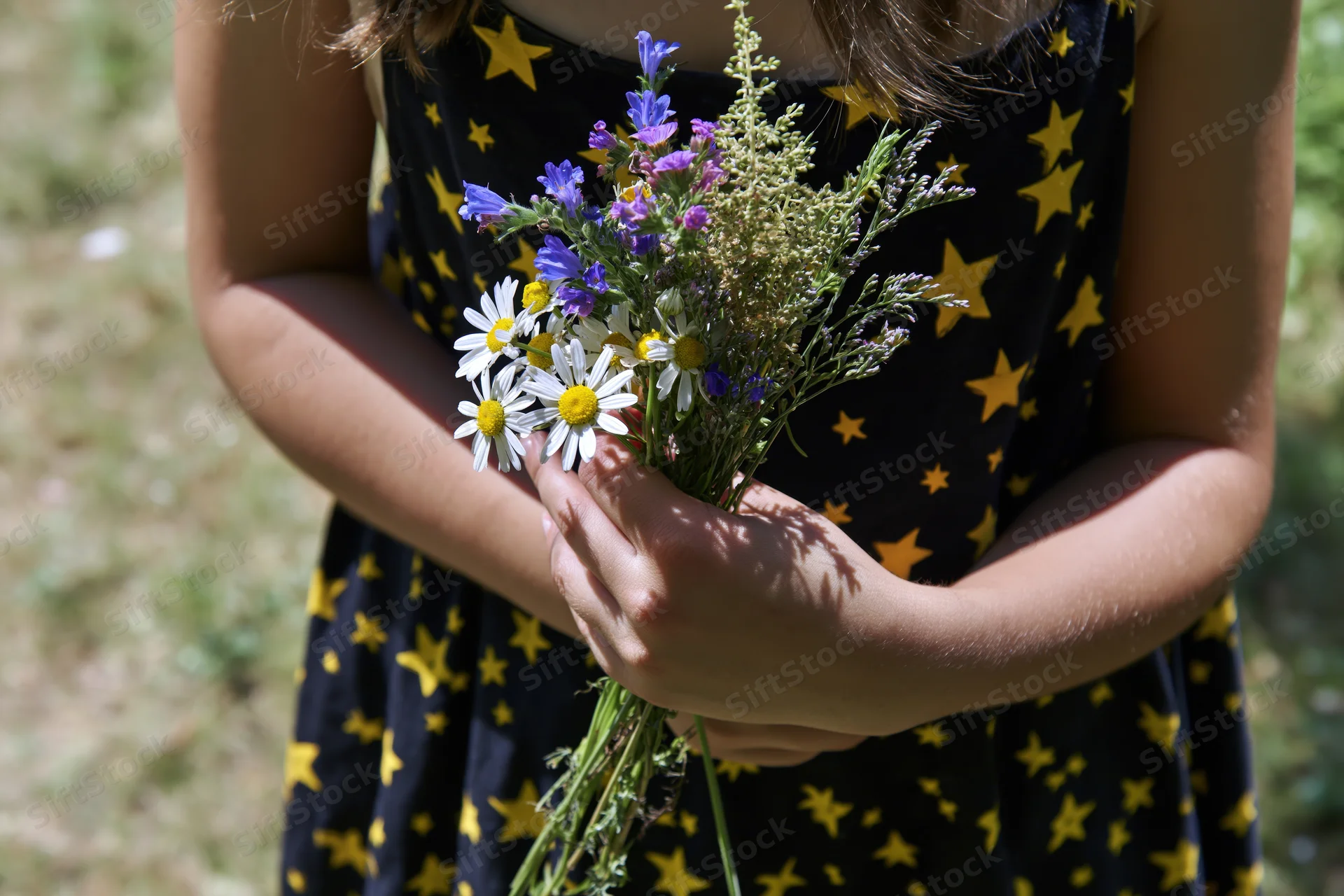 Girl holding a bouquet of wildflowers in a field
